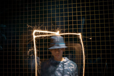 Portrait of man against illuminated wall