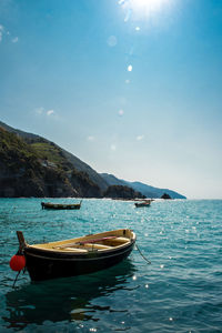 Boats moored on sea against sky