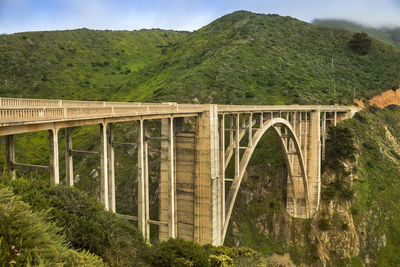 Arch bridge over river amidst mountains