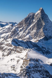 Scenic view of mountains against clear blue sky