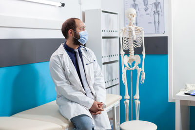 Doctor wearing mask sitting at hospital