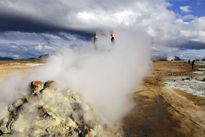 Cropped hand of person at volcanic landscape