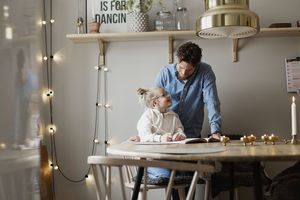 Father helping daughter doing homework