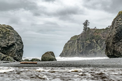 Rock formations by sea against sky
