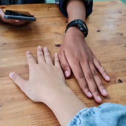 High angle view of hands on table