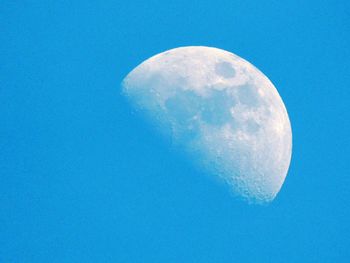 Low angle view of moon against blue sky