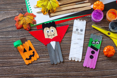 Halloween ghost, pumpkin, mummy and vampire toy gift stics puppets on wooden table. handmade. 