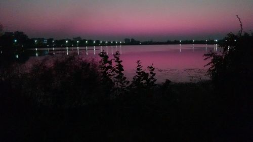 Scenic view of lake against sky at night