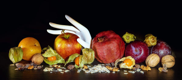 Close-up of fruits on table against black background