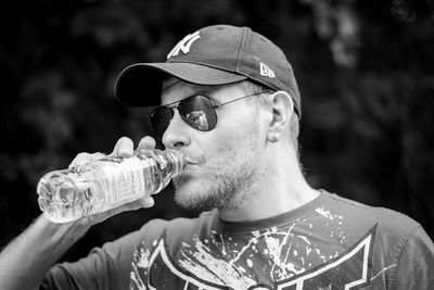 Portrait of young man drinking glasses outdoors