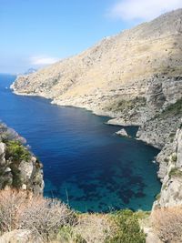 Scenic view of sea and mountains against sky