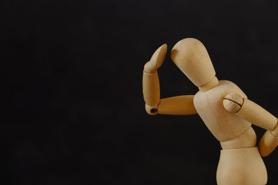 Wooden mannequin against black background