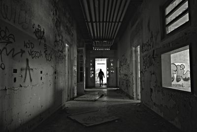 Rear view of man walking in corridor of building