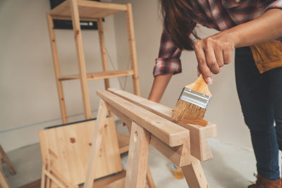 Midsection of woman holding umbrella on table