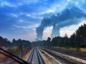 Railroad track against cloudy sky