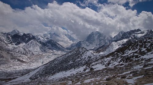 Majestic snow covered mountains against cloudy sky