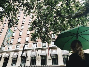 Rear view of woman on building during rainy season