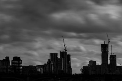 Buildings in city against cloudy sky