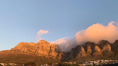 Smoke emitting from mountain against sky