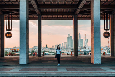 Rear view of woman standing by buildings in city