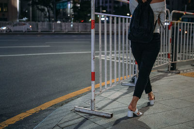 Low section of woman walking on road