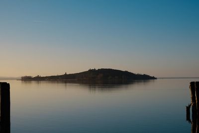 Scenic view of lake against clear sky during sunset