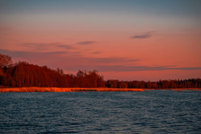 Scenic view of lake against romantic sky at sunset