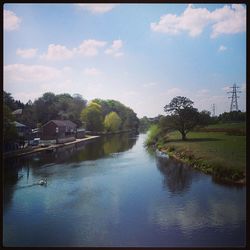 Scenic view of river against cloudy sky