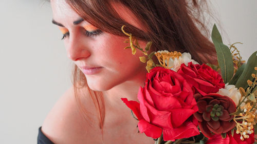 Close-up of young woman holding rose