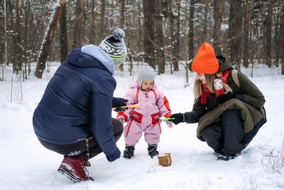 Outdoor family activities for happy winter holidays. happy father and mother playing with little