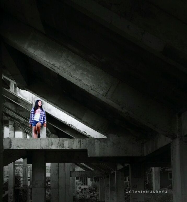 FULL LENGTH OF MAN STANDING ON FOOTBRIDGE IN RAILROAD STATION