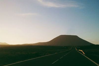 Empty road leading towards mountains