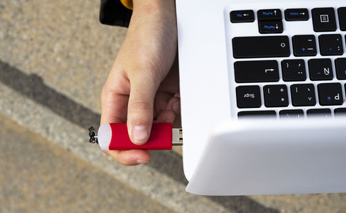 Hand connecting a pendrive to the laptop.