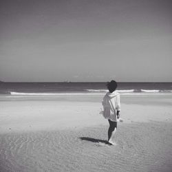 Rear view of woman standing on beach
