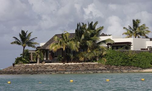 Palm trees by swimming pool by sea against sky