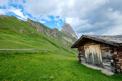 Mountain summer hut surrounded by beautiful greenery and mountains, val gardena, dolomites, italy.