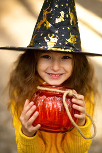 Portrait of smiling girl holding glass pumpkin