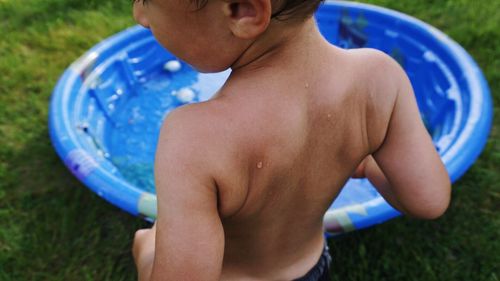 Close-up portrait of a boy by swimming pool