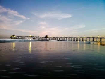 Pier over sea against sky during sunset