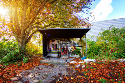 Gazebo in park by building against sky during autumn