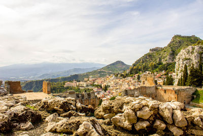 Townscape by mountains against sky