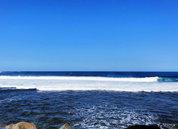 Scenic view of sea against clear blue sky