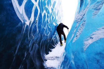 Low angle view of man swimming in sea during winter