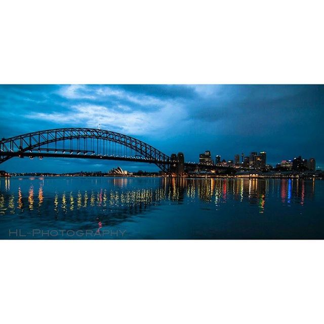 water, illuminated, sky, architecture, built structure, night, waterfront, reflection, sea, dusk, river, building exterior, cloud - sky, blue, connection, auto post production filter, city, bridge - man made structure, cloud, outdoors