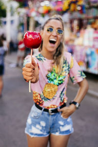 Cheerful lady having fun enjoying sweet candy apple