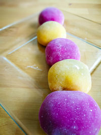 Colourful japanese mochi in a transparent plate on wooden background.