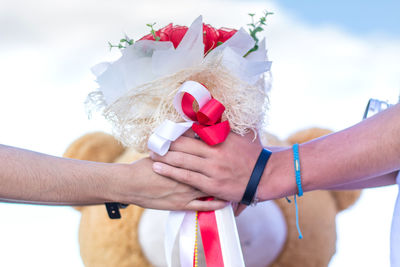 Cropped image of man proposing woman by giving bouquet