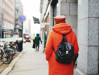 Rear view of woman with bicycle on street