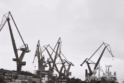 Cranes at construction site against sky