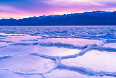 Scenic view of frozen lake against sky during sunset